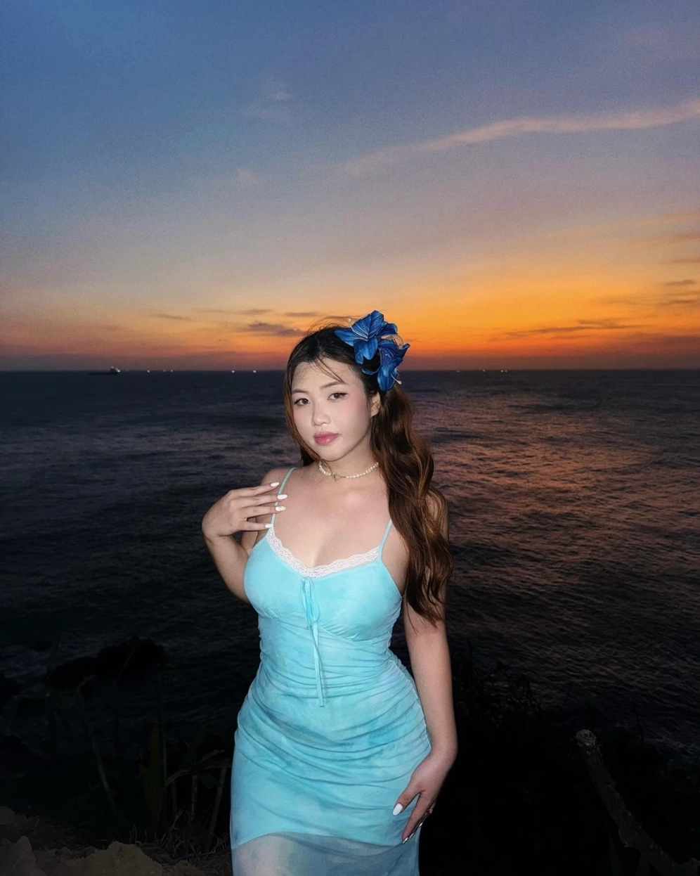 Cô gái buồn bã ngồi lặng lẽ bên khung cửa sổ ngắm hoàng hôn