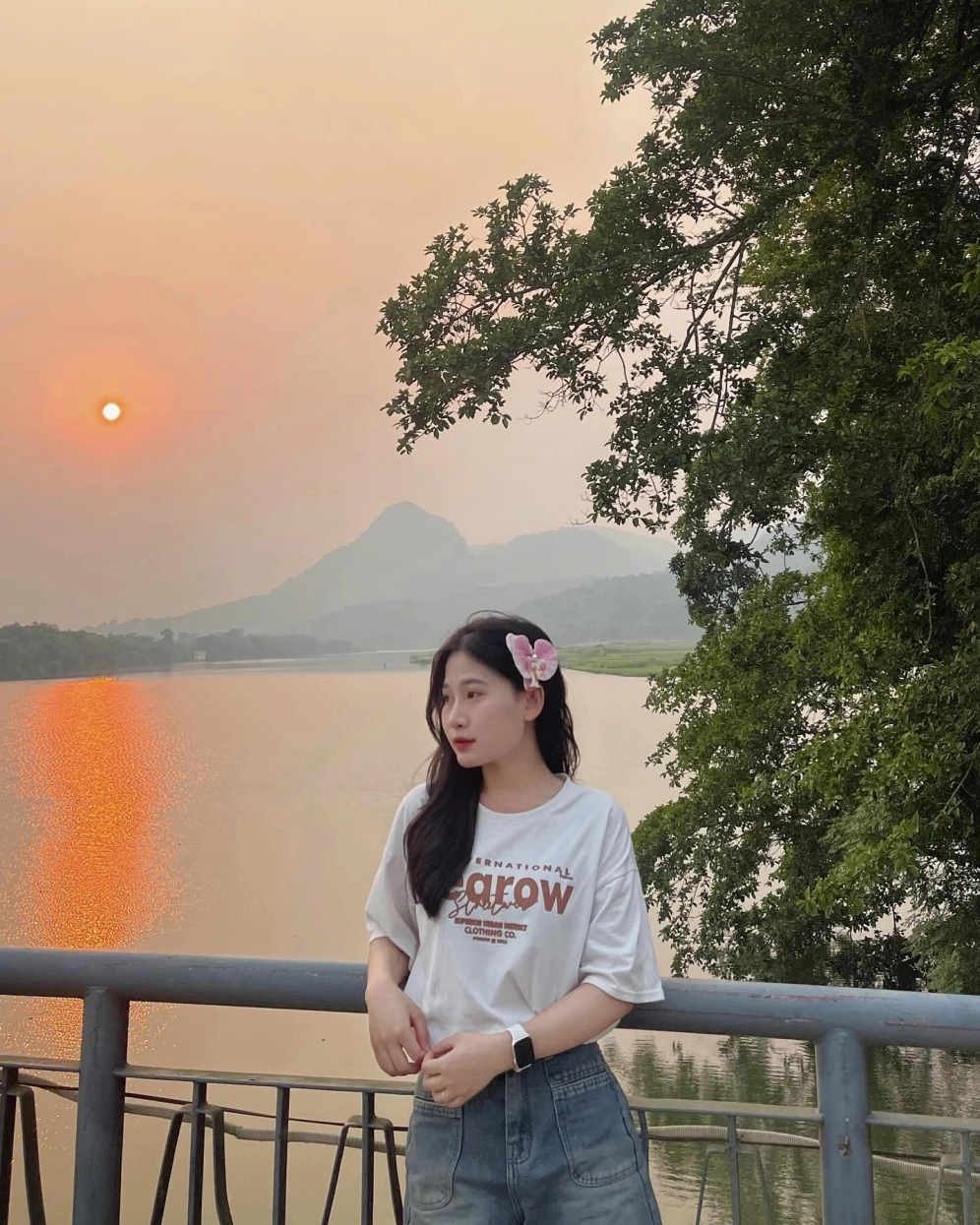 Cô gái nở nụ cười tươi tắn dưới ánh hoàng hôn rực rỡ