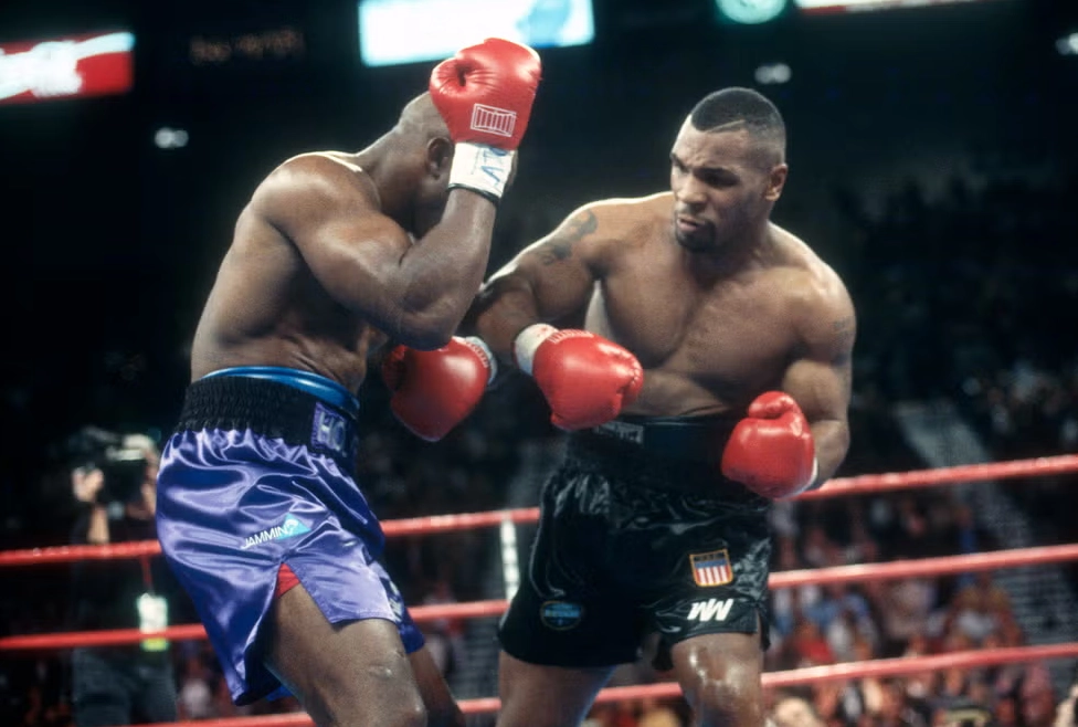 Mike Tyson tung cú đấm mạnh mẽ về phía trước trong trận đấu quyền anh với Evander Holyfield