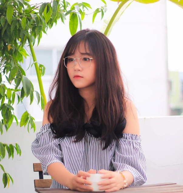 Nụ cười mỉm duyên dáng e ấp của thiếu nữ đeo kính gọng tròn đáng yêu